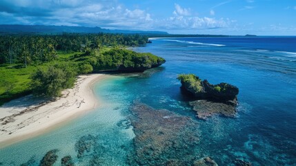 Fototapeta premium Aerial view of a pristine beach and small rocky islet surrounded by clear blue waters and lush greenery under a vibrant sky