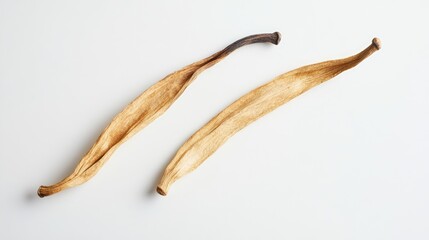 Dried vanilla pods displayed in unique foreshortenings against a bright white background showcasing their texture and natural colors