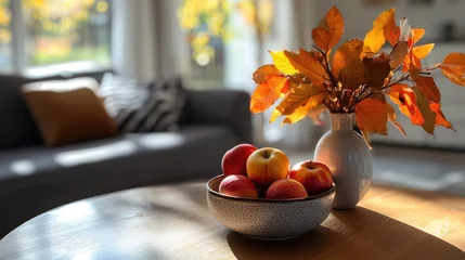 Foto op Canvas Autumn-themed living room scene featuring a cozy house setting with a vase of vibrant autumn leaves and a bowl of ripe red apples on a round wooden table, interior design, seasonal decor, warmth. © MetaPixel