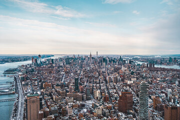 Obraz premium Stunning Aerial View of New York City Skyline Captured on a Crisp Winter Day Highlighting Skyscrapers and Urban Landscape With Snow-Covered Buildings Near the East River and Hudson River