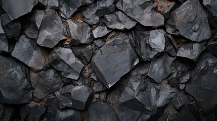 Rough unfinished black rock texture close-up, featuring irregular shapes and surfaces that create a rugged background, natural materials, abstract design, versatile use.