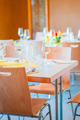 Restaurant Table Setting with Wine Glasses and Yellow Napkins in a Modern Dining Environment Creating a Sophisticated and Inviting Atmosphere for Gourmet Dining Experiences and Special Occasions