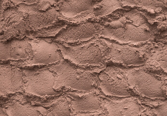 Ice cream texture. Appetizing and delicious background of chocolate ice cream arranged in hemispheres. Textured background of a wall made of plaster. Mocha Mousse, Color of the Year 2025.