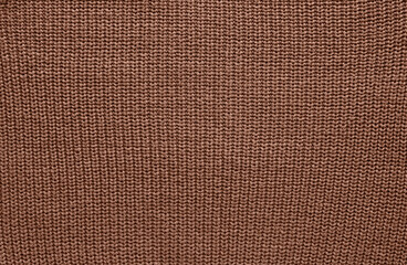 Texture of smooth knitted sweater with pattern. Handmade knitting wool or cotton fabric texture. Background of Large knit pattern with knitting needles or crochet.  Mocha Mousse colour of 2025 year