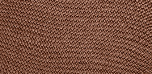 Texture of smooth knitted sweater with pattern. Handmade knitting wool or cotton fabric texture. Background of Large knit pattern with knitting needles or crochet.  Mocha Mousse colour of 2025 year