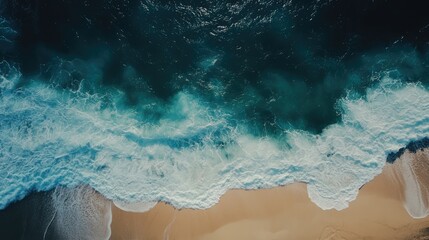Obraz premium Aerial view of crashing ocean waves meeting sandy beach shoreline under clear blue skies