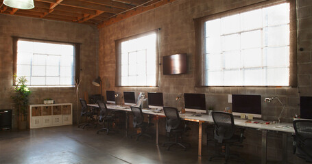 Empty Interior Of Modern Open Plan Design Office With Row Of Computers On Desk
