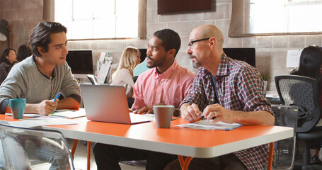 Three Designers In Creative Business Using Laptop Meeting In Modern Multi-Cultural Office 