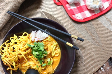 Golden egg noodles and vibrant green garnishes contrast beautifully against the rich, creamy curry in this mouthwatering Khao Soi.
