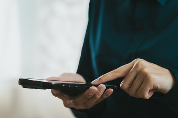 person using smartphone with focused expression, showcasing modern technology and communication. setting appears to be indoors, emphasizing casual atmosphere