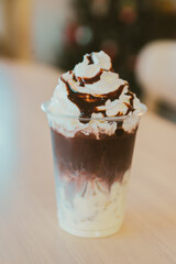 Delicious dessert in cup with whipped cream and chocolate sauce, perfect for sweet cravings. Enjoy this delightful treat on warm day or as special indulgence!