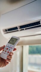 Cooling Down on Hot Day Hand Adjusting Thermostat on a Modern Wall Mounted Air Conditioner Unit.