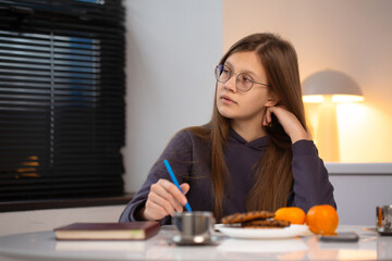 A dreamy teenage girl is writing a letter to Santa in preparation for Christmas
