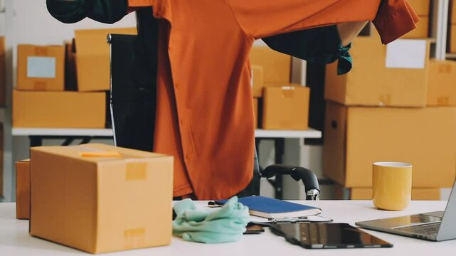 Successful young asian sme business owner working in a storage room and celebrating a successful order just received