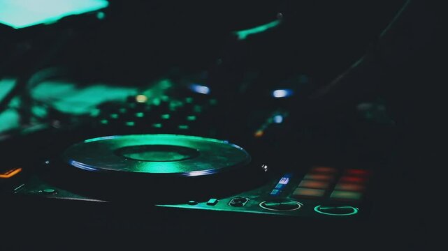 DJ work in a nightclub, mixing. A club DJ mixes music using an audio mixer and turntables on stage. A disc jockey plays in a club at a party.