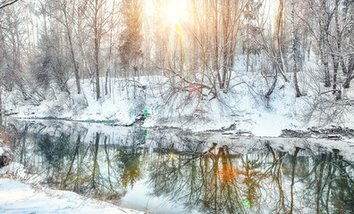 Breathtaking  landscape in city park with snowy trees and beautiful frozen river.