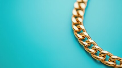 Obraz premium Sleek gold chain displayed against a vibrant blue background with elegance and style