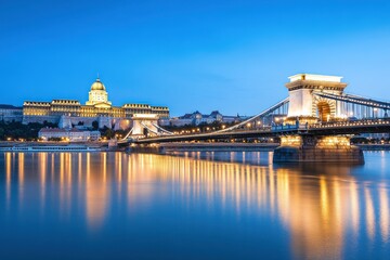 a dark blue sky and yellow light on the castle in front of the chain bridge
