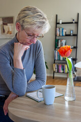 Woman reading in a notebook with a cup of tea