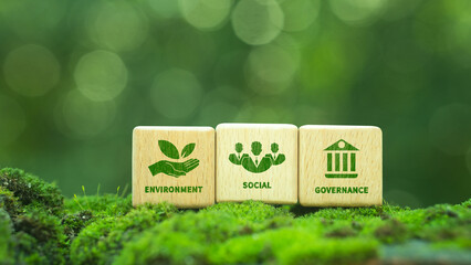 Green ESG icon on wooden block. Environment, social and governance concept. Net zero greenhouse gas emissions for a sustainable global environment. On a green forest background.