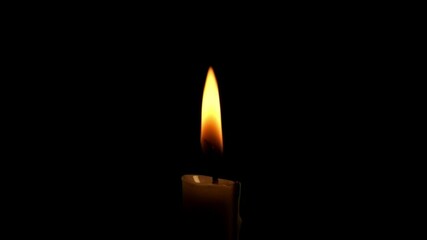 Close up of a burning candle flame isolated on a black background.The candle flame sways slowly.The concept of hope and enthusiasm.Copy space for text.Real time raw video no edit.For transition videos