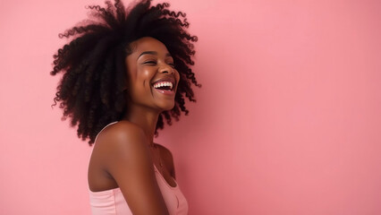 Obraz premium A young dark-skinned beautiful woman, laughing, on a pink background.