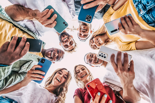 Group of multiracial young people using smart mobile phone device outside - Happy best friends laughing at camera - Trendy technology concept with guys and girls playing video games app on phone