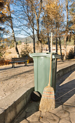 broom and trash can in autumn park