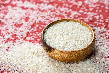 Round bowl with white rice on bamboo stand and scattered grain. Healthy nutrition and light...