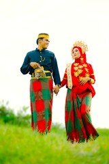 Portrait of Asian Men and Women wearing traditional Bugis clothes posing for pre-wedding