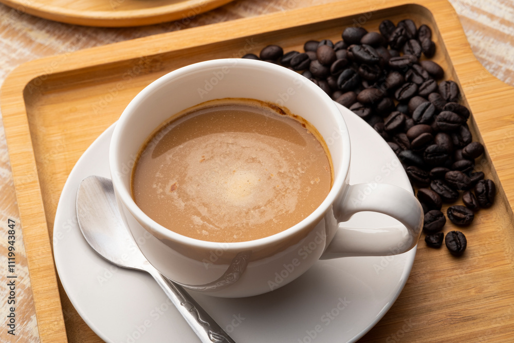 Wall mural A cup of espresso coffee with roasted beans on wood table