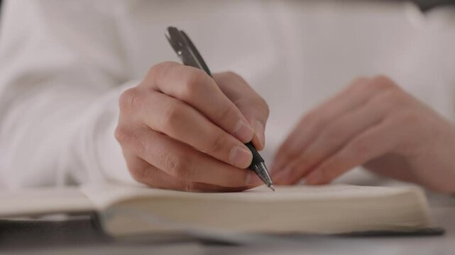 B&uuml;roangestelter schreibt etwas in sein Notizbuch
