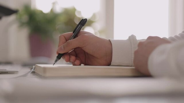 B&uuml;roangestelter schreibt etwas in sein Notizbuch