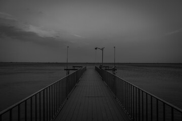 Pier with gloomy sky in the background. This photo was taken on September 15 2024 at 5:56 p.m at the Ciputih Resort, Ujung Kulon, Indonesia. 