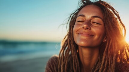 A serene woman with dreadlocks calmly embraces the warmth of the sunset by the sea, with eyes closed and a peaceful smile reflecting inner tranquility.