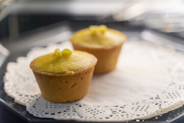 A beautifully arranged plate of lemon tarts, showcasing their vibrant yellow filling and delicate pastry crust, invites you to indulge in a delightful culinary experience. The smooth lemon curd