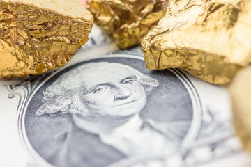 Gold and currency : The intersection of tangible and monetary value. A U.S. dollar bill featuring George Washington and gold nuggets, depicting the timeless allure of gold as a valuable asset. © William W. Potter