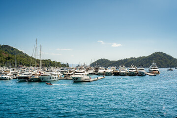 Obraz premium Port marina of Gocek in Turkey with many docked superyachts, sailing and motor boats on a sunny day with blue sky