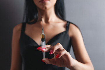 Fototapeta premium woman holding syringe in her hand, close up