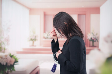 お葬式でお焼香をする女性の参列者