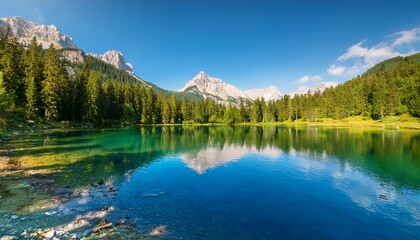 a serene mountain lake landscape in sunny day a forest and a clear blue lake reflecting the vibrant colors