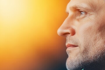 Obraz premium Profile portrait of a mature man against a soft glowing background.