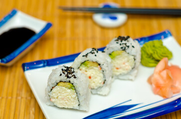 Sushi served on wooden table with black sticks