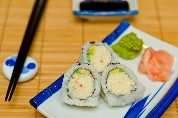 Sushi served on wooden table with black sticks