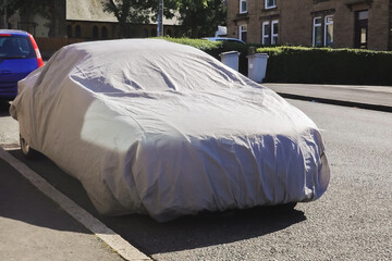 covered car on the sideway in the street
