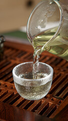 Pouring a soothing and fragrant tea into a delicate glass cup, enhancing the experience
