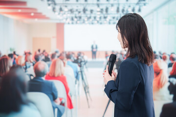 記者会見で質問をする女性の記者
