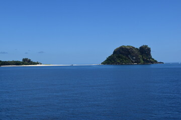 A lush green tropical paradise island with palm trees and white sandy beaches on Fiji in the...
