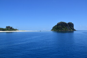 Naklejka premium A lush green tropical paradise island with palm trees and white sandy beaches on Fiji in the Pacific Ocean