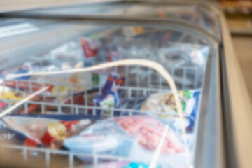 Frozen products in a chest in a store. Semi-finished products and ice cream. Close-up. Blurred.